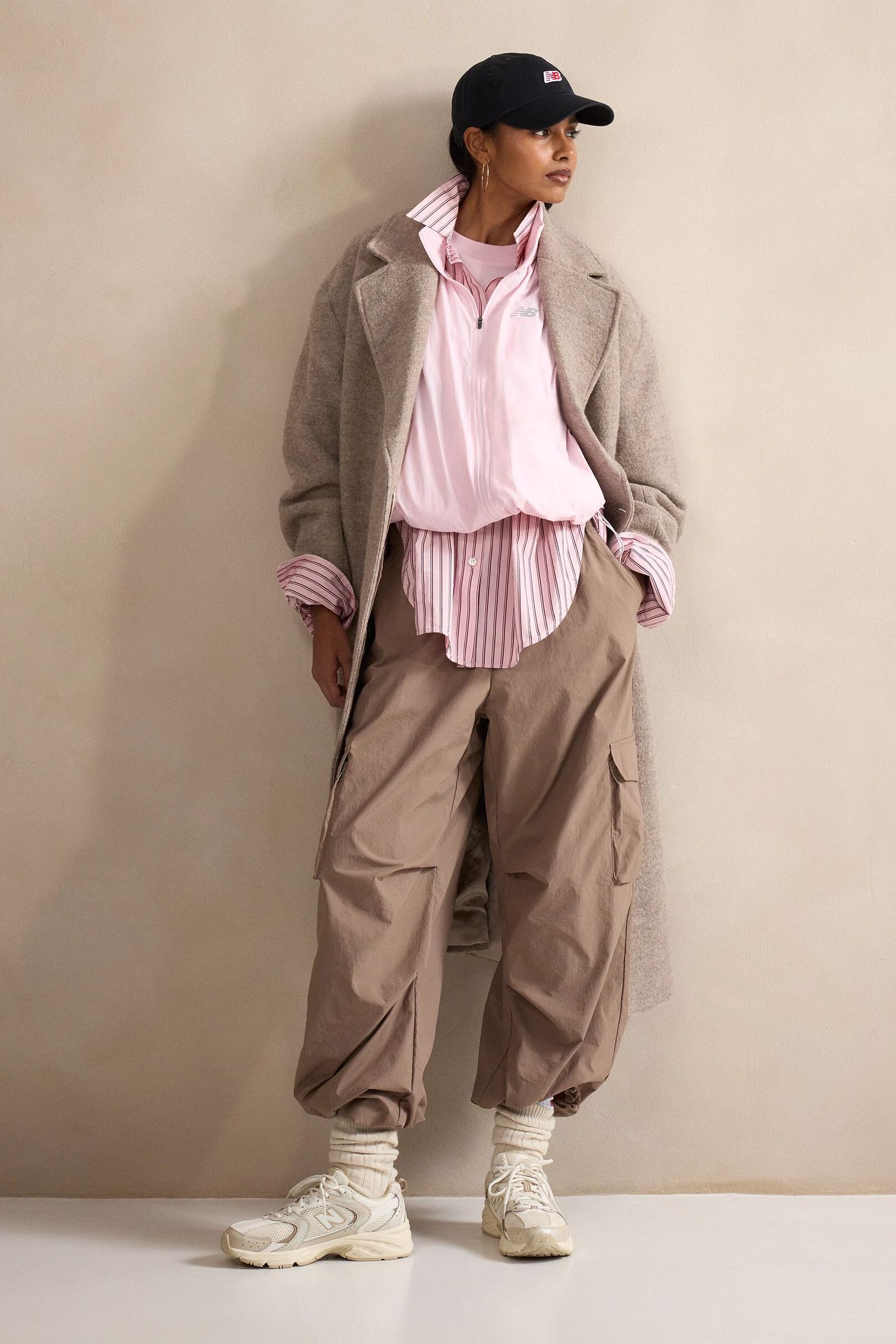 A person standing against a tan studio backdrop.